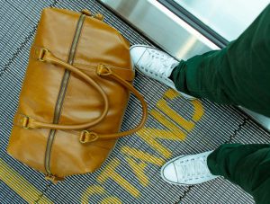 Persona sobre cinta de avance rápido en aeropuerto.