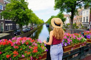 chica en los canales de amsterdam con flores