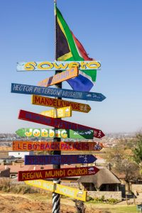 señales de colores que indican diferentes lugares como soweto, la casa de mandela, johannesburgo